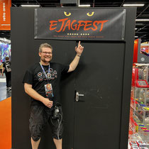 Das Bild zu Männerquatsch Podcast Folge 199 zeigt Björn vom Männerquatsch Podcast und dem ejagfest unter einem ejagfest Banner auf der Gamescom 2022.