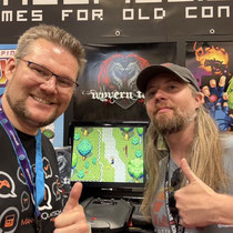 Das Bild zu Männerquatsch Podcast Folge 197 zeigt Björn mit Jasper van Turnhout mit Wyvern Tales 2 für den Jaguar in der Retro Area auf der Gamescom 2025.