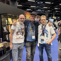 Das Bild zu Männerquatsch Podcast Folge 197 zeigt Peter Thierolf, Lutz Osterkorn und Chris Hülsbeck am Gemeinschaftsstand von Factor 5, Kairo und Chris Hülsbeck in der Retro Area auf der Gamescom 2025.