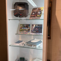 Das Bild zu Männerquatsch Podcast Folge 199 zeigt eine Vitrinen-Ausstellung auf dem ejagfest 2024 mit einem Atari Jaguar aus dem Lagerhausbrand von Funsoft aus den 1990ern, einem Jaguar im durchsichtigen Gehäuse und einem Hot Rod Dental-Cam Kit und mehr. 