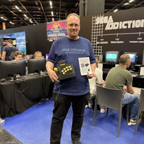 Das Bild zu Männerquatsch Podcast Folge 197 zeigt den Macher des OSA Sticks in der Retro Area auf der Gamescom 2025.