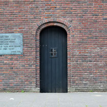 Buitenmuur van buitenaf gezien met de poort die gebruikt werd om de ter dood veroordeelde gevangenen weg te voeren naar de Waalsdorpervlakte waar men gefusilleerd werd