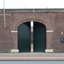 Buitenmuur van buitenaf gezien met de oorspronkelijke locatie van de toegangspoort van Oranjehotel