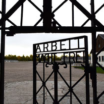 11. Poortdeur met tekst 'Arbeit Macht Frei' met zicht op de apelplaats in het kamp