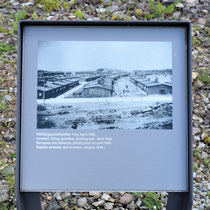 68) Informatiebord met een oude foto van de woonbarakken voor de gevangenen 