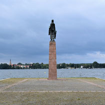 Monument bij meer met zicht op de stad 