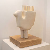 Sculpture en céramique d’Alexandra Coutand, forme organique avec reliefs en crête, posée sur socle en bois dans un espace minimaliste