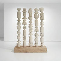 Composition de sculptures en céramique façon moucharabieh d’Alexandra Coutand, formes verticales répétées et texturées sur socle en bois, pensée pour structurer un espace intérieur, séparation d'espace artistique