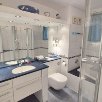 Badezimmer der Ferienwohnung Nautilus Nr. 27 mit Einbauwanne, Glasdusche, großem Spiegel und Waschtisch