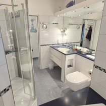 Badezimmer der Ferienwohnung Nautilus Nr. 27 mit Dusche, Waschtisch und praktischen Ablageflächen