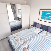 Schlafzimmer der Ferienwohnung Nautilus Nr. 27 mit Doppelbett und großem Kleiderschrank