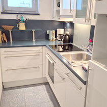 Küche der Ferienwohnung Nautilus Nr. 27 mit Ceran-Kochfeld, Backofen, Mikrowelle und Geschirrspülmaschine