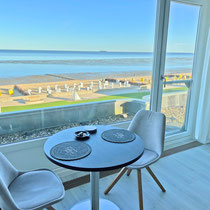 Essplatz am Fenster mit weitem Blick über Strand, Watt und Nordsee