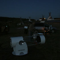 Plantada de telescopios con las cabañas y tipis al fondo.