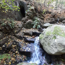 Kleiner Wasserfall mit Höhle dahinter