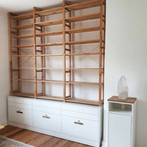 Sideboard mit offenem Regal und kleine Vitrine mit eingelassenem Riesenkristall, Kombination aus warmen Holz und schlichten weißen Flächen