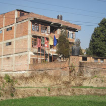 along the wall of the school