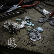 Trabajo en mesa de piezas de plata con larimar.