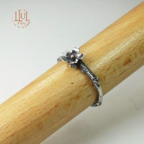 Anillo de rama con flor hecho en plata 950 y bolita central de cobre.