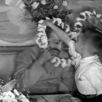 1956 ; Young Larry Karrasch garlanding Meher Baba at Longchamps Restaurant, New York.