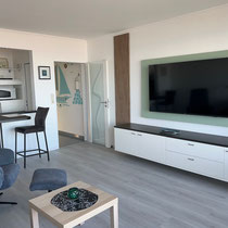 Wohnraum der Ferienwohnung Nautilus Nr. 27 mit TV und offener Küchenzeile