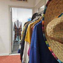 ein Blick in die Sologarderoben - im Vordergrund ein bunt gefüllter Kostümwagen und einem Sombrero an der Stirnseite 