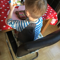 Sitzerhöhung auf Stuhl mit Kind