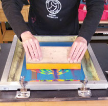 TTeilnehmer bedruckt Geschirrtuch im Siebdruck-Workshop in der Druckwerkstatt Ganderkesee.