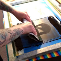 Eine Person druckt mit einer Rakel Frabe durch das Sieb im Workshop Siebdruck in der Nähe von Oldenburg.