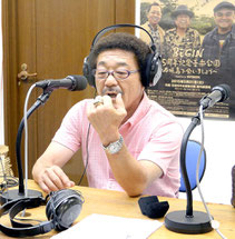ラジオの生放送で殿堂入りの記念指輪の話をする具志堅さん=20日夕、FMいしがきサンサンラジオ