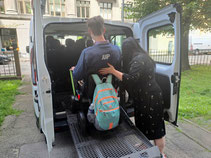 White miniman dspecialised for disabled travellers loading a young man in a wheelchair