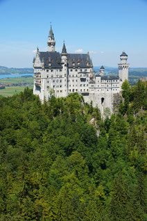 Schloss Neuschwanstein bei sonnigem Wetter mit Forggensee im Hintergrund