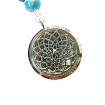 Duftanhänger mit Lebensblume-Motiv an einer türkisfarbenen Mala – vereint feine Duftimpulse mit spiritueller Symbolkraft.
