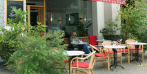 Eine junge Frau geniesst die Sonne bei Kaffee und Kuchen. Café beim Savignyplatz. Foto: Helga Karl