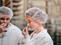 Zwei Personen in Hygienekleidung verkosten Käse im Felsenkeller