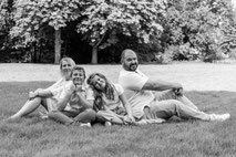 Familienshooting in Essen – Eltern mit Sohn und Tochter sitzend auf einer Wiese im Park, natürliche und entspannte Familienfotografie