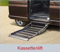 Ausgefahrener Kassettenlift unterhalb der Schiebetür eines braunen Multivans.