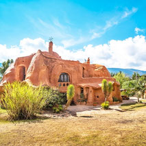 Terracotta-Haus in Villa de Leyva bei Sommenschein umgeben von tropischen Pflanzen