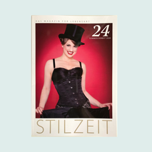 Die Künstlerin Zoë MacTaggart mit Zylinder in schwarzem Korsett vor rotem Hintergrund auf dem Cover des Hochglanzmagazins Stilzeit der Schaumburger Nachrichten