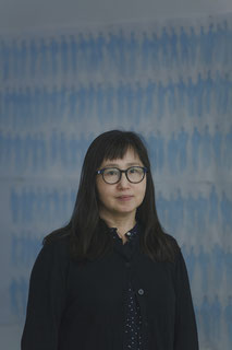 Das Bild zeigt die Autorin Don Mee Choi mit schulterlangen Haaren und Brille.
