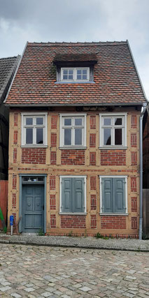 Ein kleines Stadthaus mit grauen Fensterläden
