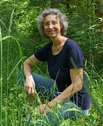 Nicole Bangel sitzt in der Hocke im Wald.