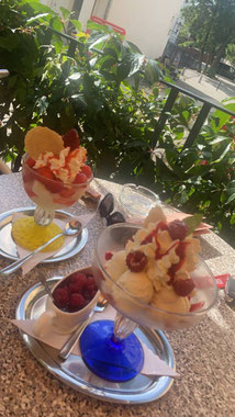 Zwei Eisbecher stehen auf einem Cafétisch