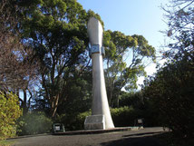 紅白梅樹に囲まれた軍転記念の塔