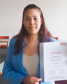 Clara Matos Garcia posiert mit Urkunde nach Lehrabschluss im Einzelhandel