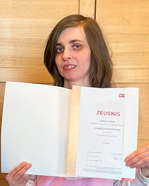 Andrea Lindner präsentiert das Diplom zur Einzelhandelskauffrau