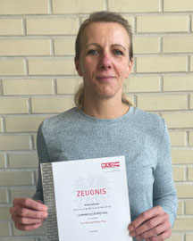 Anita Scherer hält ihr Zeugnis in Betriebslogistik in den Händen