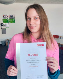 Stefanie Veigl mit Urkunde zur erfolgreich bestandenen Einzelhandelsprüfung