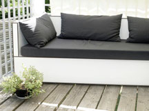 Individuell gefertigte Balkon-Lounge aus Vollkernplatten mit wetterfesten Outdoor-Polstern als platzsparende Sitz- und Liegelösung für einen kleinen Balkon. 
