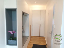 Flurschrank über Eck - Scheinerei Holzdesign Ralf Rapp, Flurmöbel in weiß mit grauer Garderobennische mit matt schwarzer Kleiderstange u. Dekorationsnische, Garderobenschrank über Eck in weiß & grau mit Massivholz-Eichengriffleisten & Dekorationsnische 
